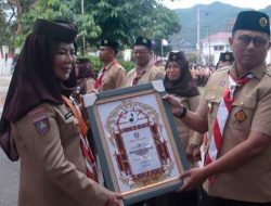 Penjabat Gubernur Gorontalo Hamka Hendra Noer ketika menyerahkan penghargaan kepada Ketua Kwarda Gorontalo, Idah Syahidah Habibie usai Apel Besar Gerakan Pramuka dalam rangka Hari Pramuka ke-61 Tingkat Kwartir Daerah (Kwarda) Gerakan Pramuka Gorontalo bertempat di halaman Rumah Jabatan Gubernur Gorontalo, Kota Gorontalo, Minggu (18/9/2022). (Foto :Ist/ Diskominfotik)