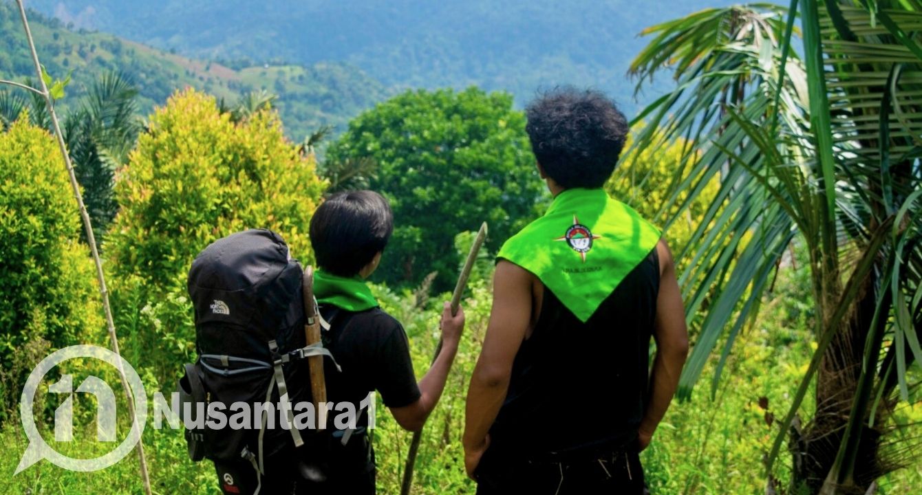 Dua orang pendaki, saat beristirahat dan ditemani pemandangan alam di sekitar jalur pendakian puncak Gunung Palakala, Desa Dulamayo Utara, Kecamatan Telaga Biru, Kabupaten Gorontalo, Minggu, 31 Agustus 2025. [foto: fikarbuntuan/nusantara1]