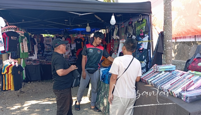 Pedagan asal Jakarta yang menjual kaos bertema Penas. [foto:juna/nusantara1]