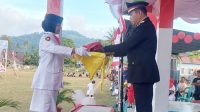 Kapolsek Suwawa, IPTU. Ismet Ishak menerima bendera merah putih saat bertindak sebagai Irup pada Upacara Penurunan Bendera di Pinogu. [foto:dok]