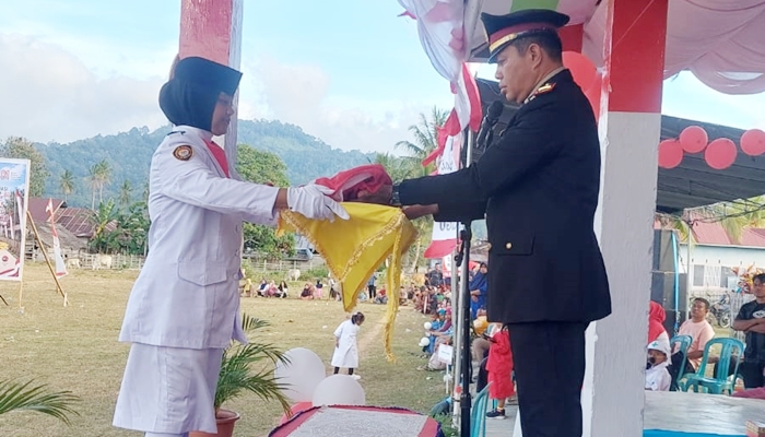 Kapolsek Suwawa, IPTU. Ismet Ishak menerima bendera merah putih saat bertindak sebagai Irup pada Upacara Penurunan Bendera di Pinogu. [foto:dok]