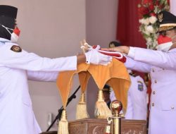 Penjagub Gorontalo, Hamka Hendra Noer ketika menyerahkan Bendera Merah Putih kepada tim Paskibraka pada peringatan HUT ke-77 RI di halaman Rujab Gubernur, Rabu (17/8/2022). (Foto : Ist/Diskominfotik)