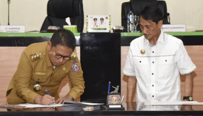 Penjagub Gorontalo, Hamka Hendra Noer menandatangani dokumen serah terima terminal Limboto di Kantor Bupati Gorontalo, Senin (15/8/2022). (Foto: Ist/Humas)