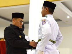 Penjagub Gorontalo, Hamka Hendra Noer saat memasang kendit yang menandai pengukuhan Paskibraka Provinsi Gorontalo tahun 2022 di Belle Li Mbui, Kota Gorontalo, Senin (15/8/2022). (Foto: Ist)