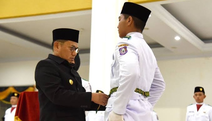 Penjagub Gorontalo, Hamka Hendra Noer saat memasang kendit yang menandai pengukuhan Paskibraka Provinsi Gorontalo tahun 2022 di Belle Li Mbui, Kota Gorontalo, Senin (15/8/2022). (Foto: Ist)