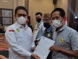 Penjagub Gorontalo, Hamka Hendra Noer saat menyerahkan asuransi hewan ternak pada kegiatan peluncuran aplikasi SiPakLan di Hotel Aston, Kota Gorontalo, Sabtu (13/8/2022). (Foto: Istimewa)