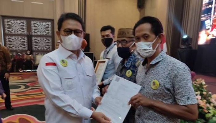 Penjagub Gorontalo, Hamka Hendra Noer saat menyerahkan asuransi hewan ternak pada kegiatan peluncuran aplikasi SiPakLan di Hotel Aston, Kota Gorontalo, Sabtu (13/8/2022). (Foto: Istimewa)