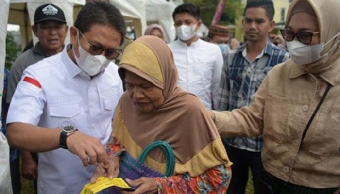 Penjagub Gorontalo, Hamka Hendra Noer didampingi Gamaria Monoarfa saat berbincang dengan salah satu pembeli di pasar murah yang dilaksanakan di halaman Kantor Diskoperindag Provinsi Gorontalo, Jumat (8/7/2022). (Foto: Istimewa)