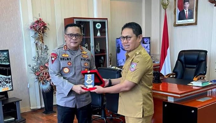 Penjagub Gorontalo, Hamka Hendra Noer ketika menerima plakat Polda Gorontalo yang diserahkan Kapolda Gorontalo, Irjen Pol Helmy Santika. (Foto : Istimewa)