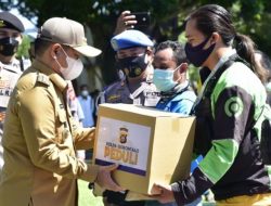 Penjabat Gubernur Gorontalo Hamka Hendra Noer menyerahkan bantuan sosial Polda Gorontalo kepada salah pengemudi ojek online di halaman Polda Gorontalo, Selasa (13/9/2022). (Foto:Ist/Diskominfotik)