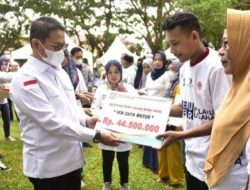 Botu 36 Penjagub Gorontalo, Hamka Hendra Noer, ketika menyerahkan secara simbolis bantuan kepada pelaku UMKM, Jumat (18/11/2022) di halaman kantor Diskumperindag. (Foto:Ist/Diskominfotik)