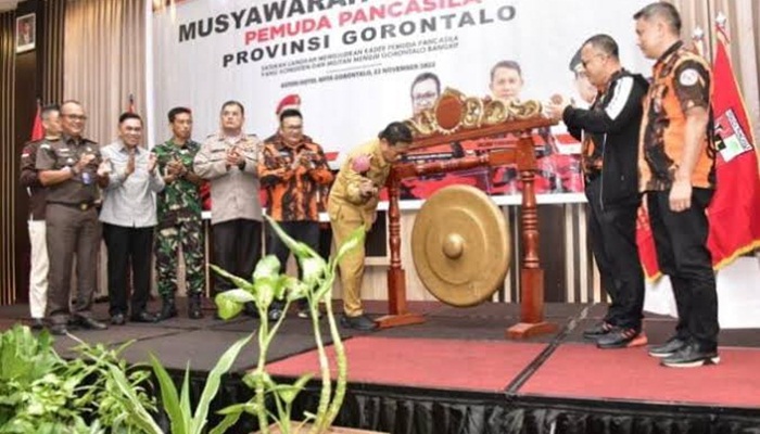 Penjagub Gorontalo, Hamka Hendra Noer (tengah) ketika memukul gong sebagai tanda dibukanya Muswil IV Pemuda Pancasila Provinsi Gorontalo di Hotel Aston, Kota Gorontalo, Selasa (22/11/2022). (Foto:Ist/ Diskominfotik)