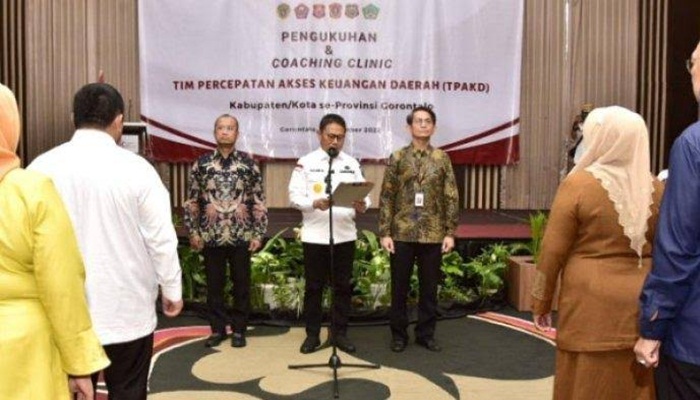 Penjagub Hamka Hendra Noer (tengah), mengukuhkan TPAKD kabupaten/kota se Provinsi Gorontalo di Hotel Aston, Kota Gorontalo, Rabu (7/12/2022). (Foto: Ist/ Diskominfotik)