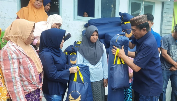 Ketua DPD Partai Nasdem yang juga Wakil Ketua DPRD Gorontalo Utara Roni Imran saat menyalurkan bantuan bagi korban banjir di Desa Potanga. (Foto:Ist)