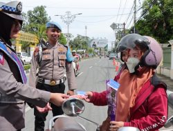 Petugas dari Satlantas Polresta Gorontalo Kota saat menyerahkan bunga dan coklat kepada pengendara yang tertib lalu lintas di momen Hari Valentin. (Foto: Ist)