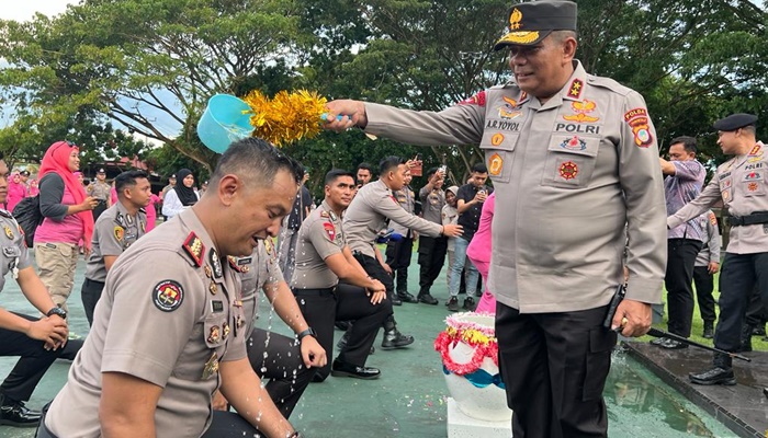 Kapolda Gorontalo, Irjen Pol. Drs. Angesta Romano Yoyol, M.M saat menyiram air kepada Kabid Humas Polda Gorontalo, Kombes Pol. Desmont Harjendro A.P, S.I.K., M.T sebagai salah satu tradisi ketika seseorang naik pangkat. (Foto: Ist)