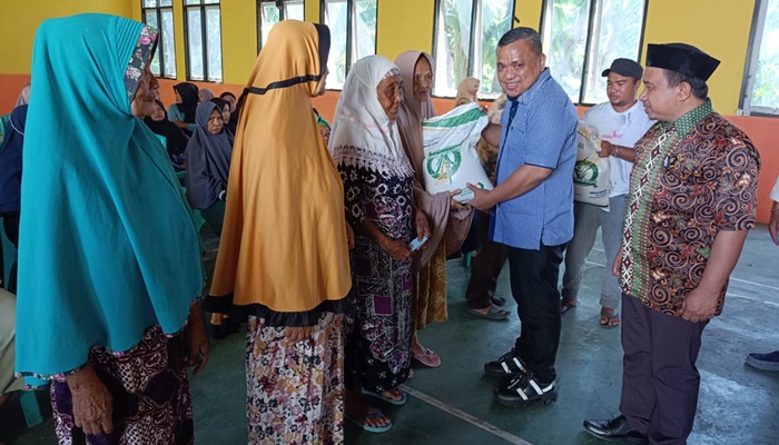 Wakil Bupati Gorontalo, Hendra Hemeto saat menyerahkan bantuan beras kepada warga Desa Tinelo. [Foto:Ist]