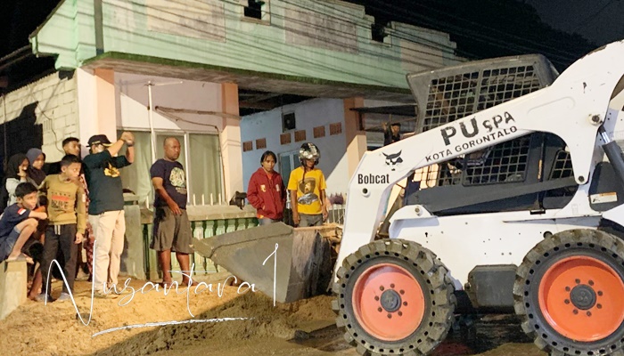 Pemerintah Kota Gorontalo saat membersihkan material longsor yang menutupi jalan. [foto:fikar buntuan/nusantara1]
