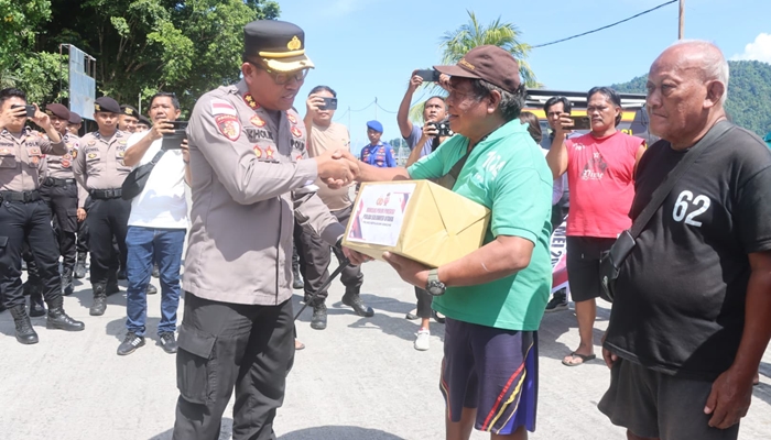 Kapolres Sangihe AKBP. Abdul Kholik saat menyerahkan bantuan kepada para TKBM pada Bakti Sosial dalam rangka Hari Buruh Nasional, Kamis (1/5) di Pelabuhan Nusantara Tahuna. [foto:ist]