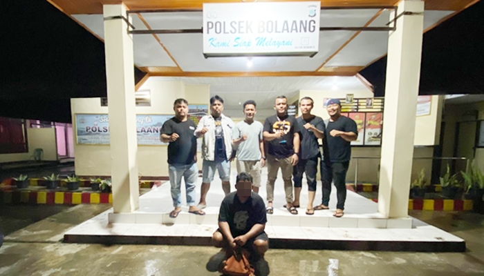 Pelaku penipuan (jongkok) saat ditahan di Polsek Bolaang, Sulawesi Utara. [foto:ist]
