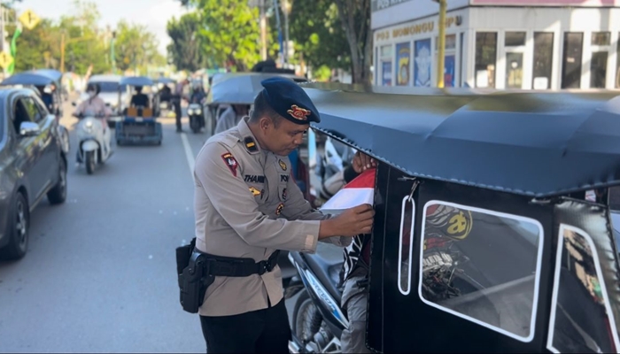 Polda 002 Merah Putih Brimob Polda Gorontalo saat membagikan Bendera Merah Putih kepada pengguna jalan. /ist