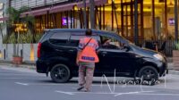Salah seorang juru parkir di Kota Gorontalo saat menerima pembayaran dari pengunjung di sekitar pertokoan Kota Gorontalo. [foto: fikar/nusantara1]