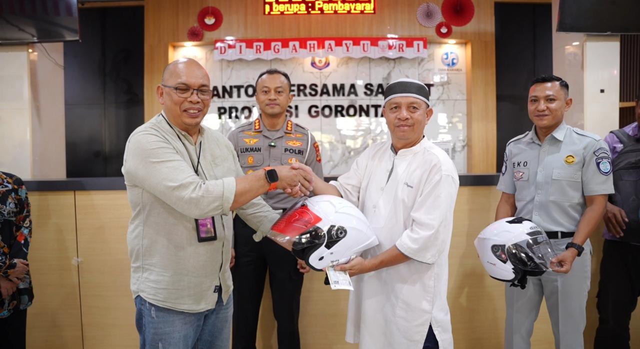 Dirlantas Polda Gorontalo Kombes Pol Lukman Cahyono bersama Kepala Jasa Raharja Gorontalo Eko Prasetyo, serta Kepala Bidang Pendapatan Badan Keuangan Provinsi Gorontalo Yendi Dude saat penyerahan helm ke masyarakat, Jumat, 19 September 2025. [foto: ist/jasaraharja]