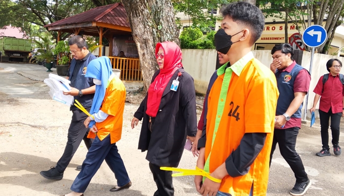 Kedua tersangka yang mengenakan kemeja tahanan saat digiring untuk ditampilkan pada konferensi pers. [foto:ist/humas]