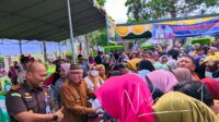 Bupati Gorontalo, Sofyan Puhi saat menyerahkan bahan pokok bersubsidi kepada masyarakat Kecamatan Limboto. [foto:juna/nusantara1]