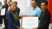 Wabup Bone Bolango Risman Tolingguhu menyerahkan Piagam Penghargaan [foto:dok/Yudi/Prokopim]