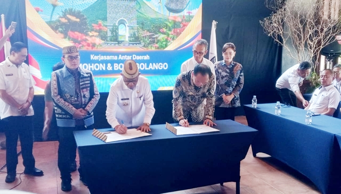 Bupati Bone Bolango Ismet Mile dan Walikota Tomohon Caroll Joram Azarias Senduk saat menandatangani PKS [foto:dok/kominfo]