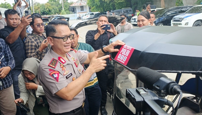 Kapolda Gorontalo, Irjen Widodo saat menempel stiker di bentor sebagai bentuk sosialisasi Call Centre 110 [foto:dok]