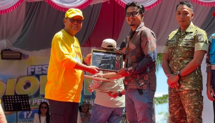 Pemberian piagam dari Bupati Gorontalo Utara Thariq Modanggu kepada PLN NP UP Gorontalo yang diwakili oleh TL SDM Umum dan CSR. [foto:dok/pln]