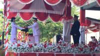 Bupati Bone Bolango, Ismet Mile saat menyerahkan bendera Merah Putih kepada Paskibraka untuk dikibarkan pada upacara HUT ke-81 Kemerdekaan RI di Lapangan Alun-Alun Bone Bolango, Senin 17 Agustus 2026. [foto:dok/indra/diskominfo]