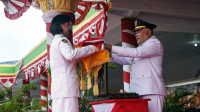 Wakil Bupati Gorontalo, Tonny S. Junus saat menerima bendera Merah Putih pada Upacara Penurunan Bendera. [foto:dok/humas]
