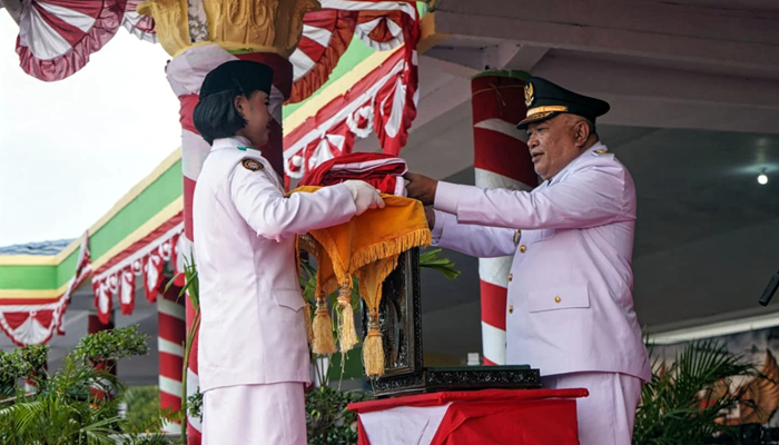 Wakil Bupati Gorontalo, Tonny S. Junus saat menerima bendera Merah Putih pada Upacara Penurunan Bendera. [foto:dok/humas]