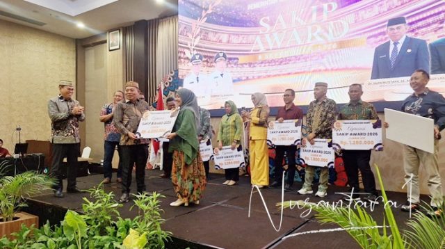Wakil Bupati Bone Bolango, Risman Tolingguhu saat menyerahkan hadiah kepada peraih nilai tertinggi SAKIP Award 2026, Kepala Dinas Kesehatan, Meyrin Kadir. [foto:dok/nusantara1]